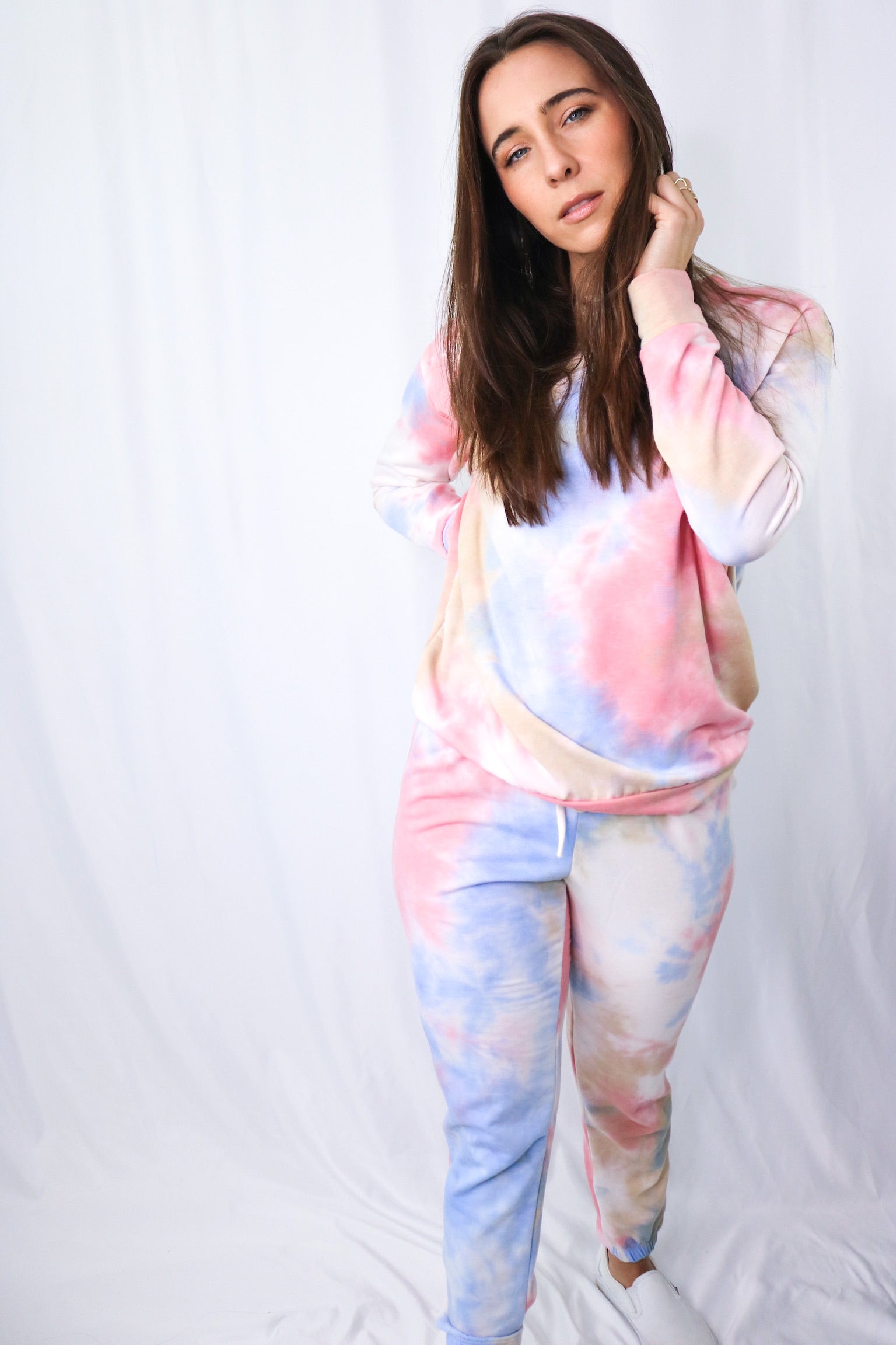 Brunette models long sleeve and pant tie dye loungewear set for Scarlette The Label, an online fashion boutique for women.