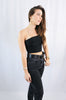Brunette girl models a black one shoulder crop top for Scarlette The Label, an online fashion boutique for women. The black one shoulder crop top is double lined. Paired with dark denim jeans.