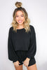 Load image into Gallery viewer, Blonde girl models matching black loungewear set for Scarlette The Label, an online fashion boutique for women. The black loungewear set comes with a long sleeve black shirt and black shorts. 