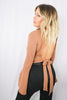 Blonde girl models keyhole flared sleeve blouse in the color Mocha for Scarlette The Label, an online fashion boutique for women. The mocha keyhole blouse is flare sleeved and open back. Paired with black pants.