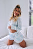 Load image into Gallery viewer, Blonde girl models a light blue tie-dye loungewear short set for Scarlette The Label, an online fashion boutique for women. The matching set comes with a long sleeve shirt and shorts.