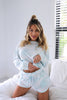 Load image into Gallery viewer, Blonde girl models a light blue tie-dye loungewear short set for Scarlette The Label, an online fashion boutique for women. The matching set comes with a long sleeve shirt and shorts.