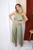 Blonde girl models strapless ruffled flare jumpsuit in sage for Scarlette The Label, an online fashion boutique for women.