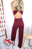 Blonde girl models open back fitted jumpsuit in burgundy for Scarlette The Label, an online fashion boutique for women. Fitted flare jumpsuit with v neck plunging neckline and open back.