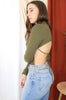 Load image into Gallery viewer, Brunette models long sleeve openback tie bodysuit in color olive for Scarlette The Label, an online fashion boutique for women. Paired with lightwash denim jeans and a gold chain belt. 