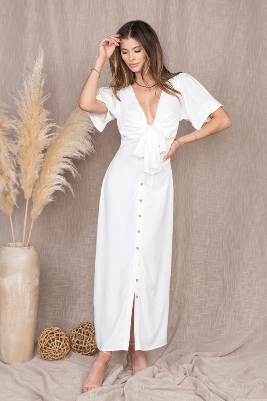 Short Sleeve Puff Sleeve buttoned maxi dress in white from Scarlette The Label, an online fashion boutique for women. Paired with gold hoops, gold clutch, and gold shoes.