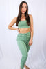 Load image into Gallery viewer, Brunette models matching jogger pant set in color: sage for Scarlette The Label, an online fashion boutique for women. Matching set comes with sage sports bra and matching joggers.