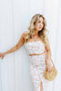 Load image into Gallery viewer, Blonde girl models a floral maxi skirt matching set for Scarlette The Label, an online fashion boutique for women.  The matching skirt set has a halter crop top and a long slitted maxi skirt. Sold separately. Paired with straw purse.