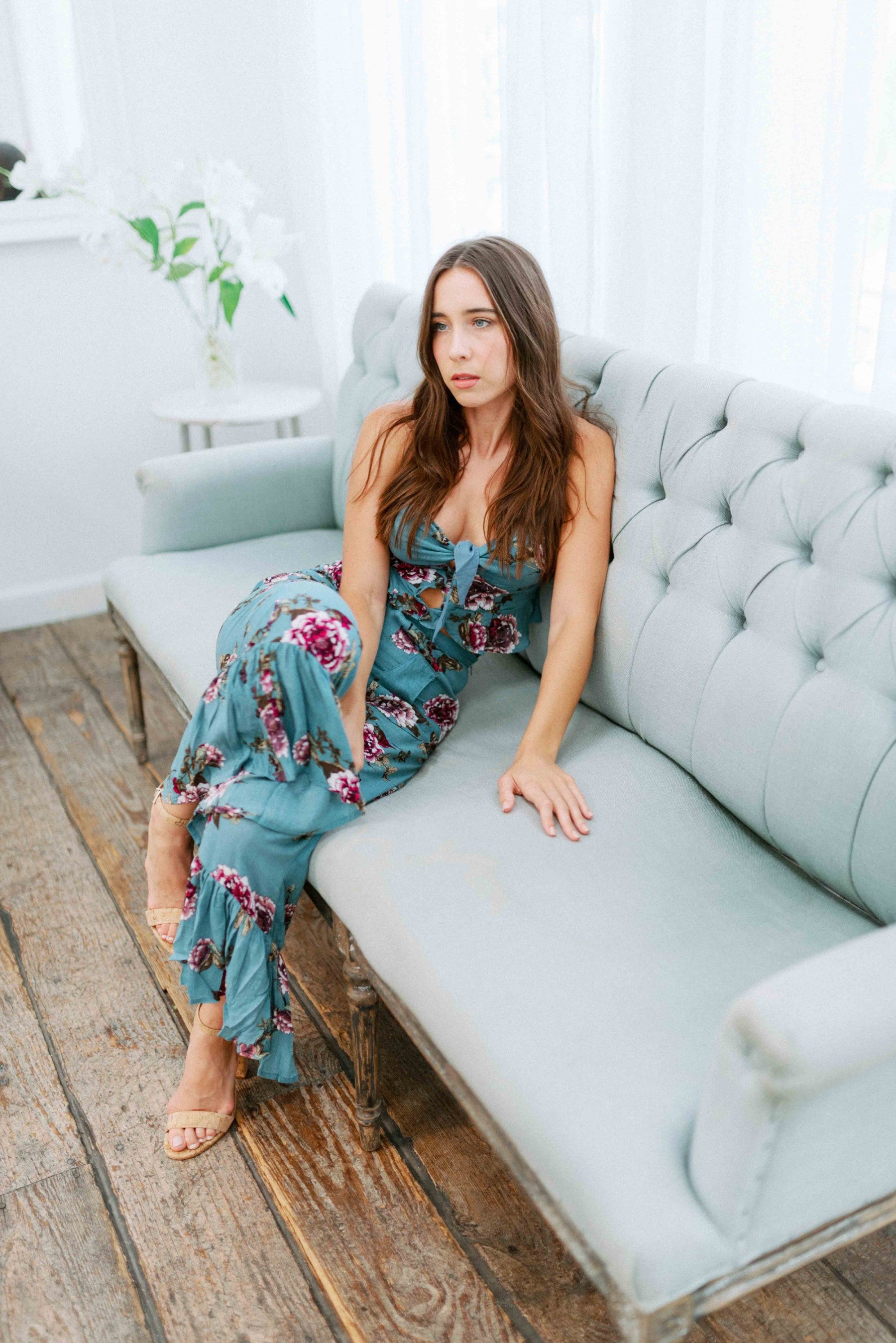 Brunette girl models a matching floral pant set (co-ord) for Scarlette The Label, an online boutique for women. The pant set is blue and has floral details. The crop top is a blue spaghetti strap tank top and the pants are blue flare pants. Paired with nude heels.