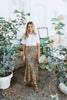 Load image into Gallery viewer, Blonde girl models midi skirt in leopard print for Scarlette The Label, an online fashion boutique for women. Midi leopard print skirt paired with a plain white tee and black heels.