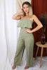 Blonde girl models strapless ruffled flare jumpsuit in sage for Scarlette The Label, an online fashion boutique for women.